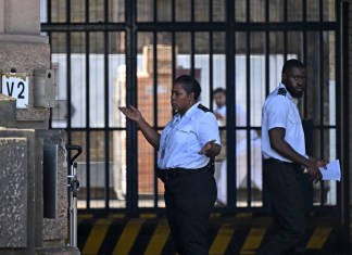 Un guardia de prisión le hace un gesto al conductor de una camioneta de reparto a las puertas de la prisión HM Wandsworth en el sur de Londres el 7 de septiembre de 2023, un día después de que el sospechoso de terrorismo, Daniel Abed Khalife, escapara de la prisión mientras esperaba el juicio.