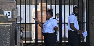 Un guardia de prisión le hace un gesto al conductor de una camioneta de reparto a las puertas de la prisión HM Wandsworth en el sur de Londres el 7 de septiembre de 2023, un día después de que el sospechoso de terrorismo, Daniel Abed Khalife, escapara de la prisión mientras esperaba el juicio.