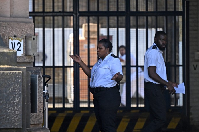 Un guardia de prisión le hace un gesto al conductor de una camioneta de reparto a las puertas de la prisión HM Wandsworth en el sur de Londres el 7 de septiembre de 2023, un día después de que el sospechoso de terrorismo, Daniel Abed Khalife, escapara de la prisión mientras esperaba el juicio.
