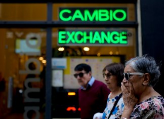 Las personas caminan frente a una casa de cambio en Buenos Aires, Argentina. Foto La Hora/AP