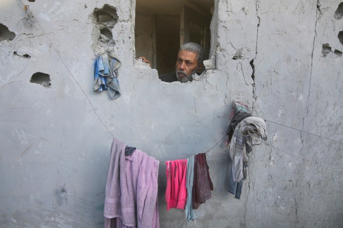 Un hombre palestino mira desde su casa dañada por ataques aéreos israelíes en Rafah, en el sur de la Franja de Gaza. Foto La Hora/AP