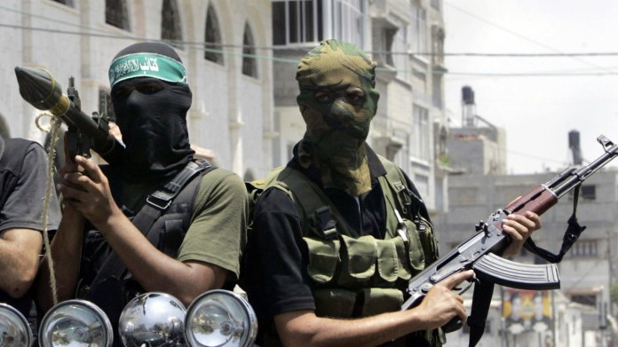 Combatientes palestinos de Hamas marchan en una camioneta con sus armas durante el funeral del extremista Emad Abu Kados, que murió durante enfrentamientos con hombres armados del movimiento Fatah