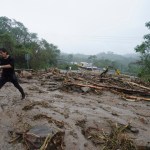 Un hombre cruza una carretera bloqueada por un deslizamiento de tierra causado por el huracán Otis