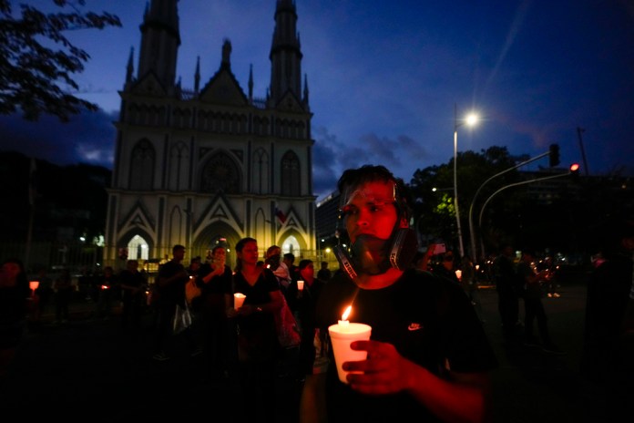 Un manifestante sostiene una vela durante una vigilia contra un recién aprobado acuerdo de minería entre el gobierno panameño y la empresa canadiense First Quantum, en la Ciudad de Panamá. Foto La Hora/AP
