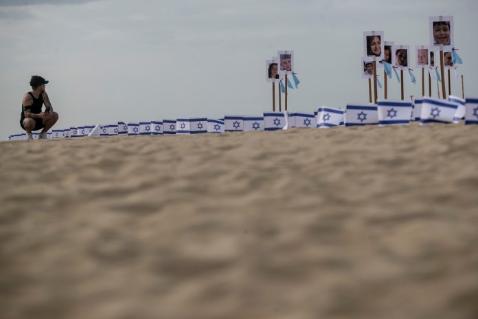 Fotografías de niños israelíes fallecidos durante la guerra entre Israel y Hamás, expuestas en la playa de Copacabana, en Río de Janeiro, Brasil. Foto La Hora/AP