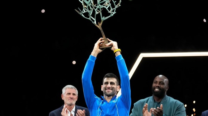 El serbio Novak Djokovic sostiene el trofeo de campeón tras ganar la final del Masters de París al superar al búlgaro Grigor Dimitrov
