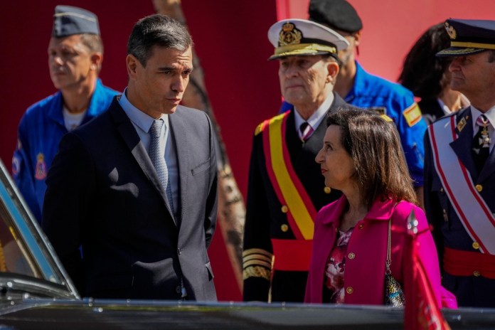 El presidente de España Pedro Sánchez habla con la ministra de Defensa Margarita Robles después de un desfile militar en el 