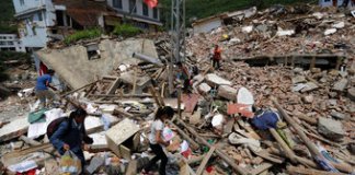 Los aldeanos cargan sus pertenencias entre los escombros de las casas destruidas. Foto: AP/La Hora