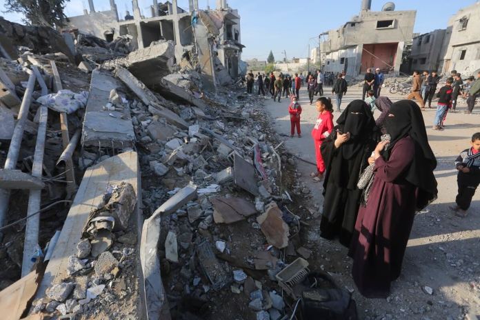Palestinos observan la destrucción causada por el bombardeo israelí de la Franja de Gaza en Rafah, el lunes 4 de diciembre de 2023. Foto La Hora / AP