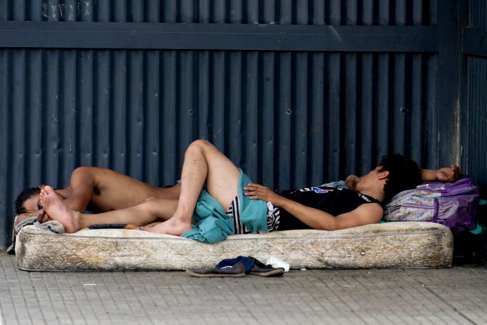 Personas sin hogar duermen en un colchón en una avenida de Buenos Aires, Argentina. Foto La Hora/AP