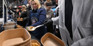 La embajadora de los Estados Unidos en Ucrania, Bridget Brink, ayuda a preparar comidas antes del primer viaje del tren de alimentos de Kiev a Kharkiv, en Kiev el 23 de noviembre de 2023