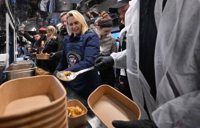 La embajadora de los Estados Unidos en Ucrania, Bridget Brink, ayuda a preparar comidas antes del primer viaje del tren de alimentos de Kiev a Kharkiv, en Kiev el 23 de noviembre de 2023