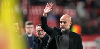 El técnico del Manchester City Pep Guardiola saluda a los aficionados antes del encuentro ante el Red Star de Belgrado en el Grupo G de la Liga de Campeones