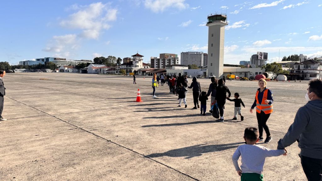 Una fila con familias y menores de edad deportados caminan en la pista de la Fuerza Aérea Guatemalteca luego de descender del avión en que retornaron de Estados Unidos. Foto La Hora / IGM. 