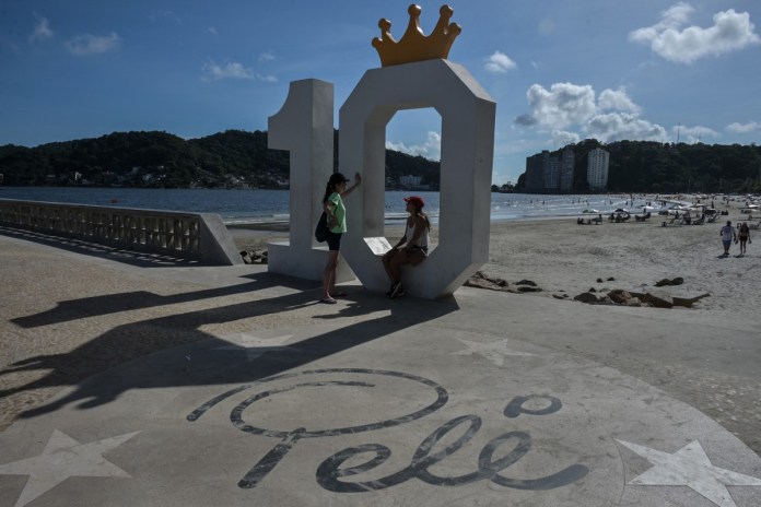 Se ve a la gente frente a un monumento en honor a la leyenda del fútbol brasileño Pelé, diseñado por el artista brasileño Luis Costa, en el muelle Rei Pele, en Sao Vicente, costa del estado de Sao Paulo, Brasil, el 19 de diciembre de 2023.