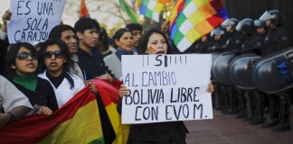 El cartel de la izquierda dice " ¡Bolivia es sólo una, diablos!” y el de la derecha "¡Sí! A cambiar Bolivia Libre con Evo M." Foto: AFP/DANIEL GARCIA