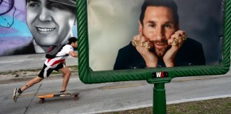 Un individuo patina cerca de un anuncio publicitario con la imagen del delantero argentino Lionel Messi. Foto: Rodrigo Abd-AP/La Hora