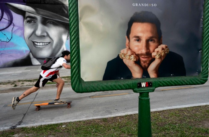 Un individuo patina cerca de un anuncio publicitario con la imagen del delantero argentino Lionel Messi. Foto: Rodrigo Abd-AP/La Hora