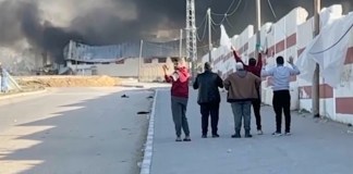 Esta imagen tomada de un video de ITV News muestra a un grupo de cinco hombres que caminan por una calle al oeste de la ciudad meridional de Jan Yunis, en Gaza, mientras levantan las manos y uno ondea una bandera blanca. El ejército israelí ha anunciado que revisará el disparo mortal a uno de los hombres. (ITV News via AP)