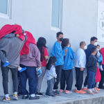 Hombre mujeres y niños hacen fila a la espera de ser registrados por Migración. Foto La Hora / IGM.