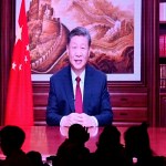 La gente cena en un restaurante mientras una pantalla transmite al presidente de China, Xi Jinping, mientras pronuncia su discurso de Año Nuevo en Beijing el 31 de diciembre de 2023.