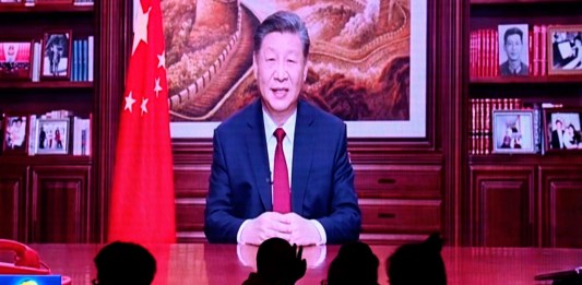 La gente cena en un restaurante mientras una pantalla transmite al presidente de China, Xi Jinping, mientras pronuncia su discurso de Año Nuevo en Beijing el 31 de diciembre de 2023.