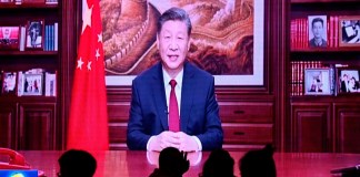 La gente cena en un restaurante mientras una pantalla transmite al presidente de China, Xi Jinping, mientras pronuncia su discurso de Año Nuevo en Beijing el 31 de diciembre de 2023.