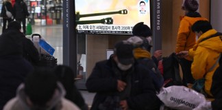 La gente ve una pantalla de televisión que muestra una transmisión de noticias con imágenes de archivo de los disparos de artillería de Corea del Norte, en una estación de ferrocarril en Seúl el 6 de enero de 2024.
