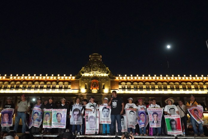 Familiares de los 43 estudiantes desaparecidos de Ayotzinapa con carteles con las imágenes y nombres de sus parientes, en el noveno aniversario de su desaparición, frente al Palacio Nacional en Ciudad de México, el 26 de septiembre de 2023. (AP Foto/Marco Ugarte, Archivo)