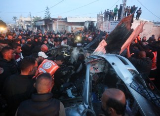 Palestinos rodean un auto alcanzado por un ataque aéreo israelí en Rafah, en la Franja de Gaza, el sábado 20 de enero de 2024. (AP Foto/Hatem Ali)