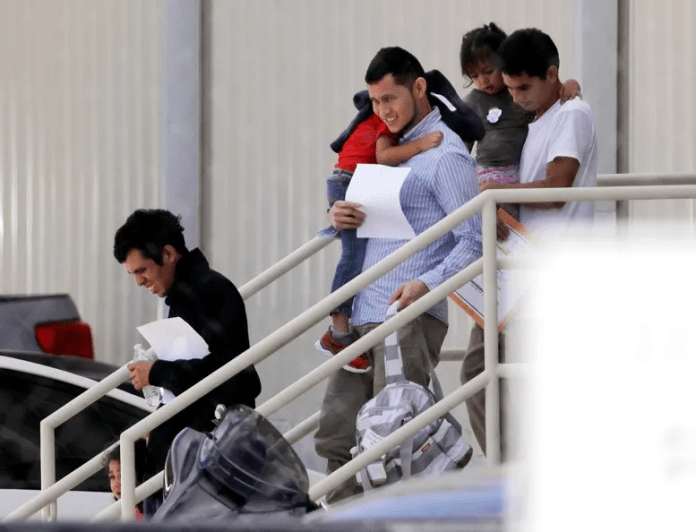Un hombre con su familia desciende de un avión luego de ser deportado por EE. UU. 