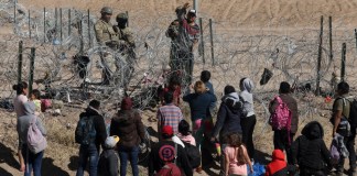 Agentes de la Guardia Nacional de Texas bloquean el paso a través de una cerca de púas a un grupo de migrantes que buscan asilo en Estados Unidos desde Ciudad Juárez, estado de Chihuahua, México, el 30 de enero de 2024.