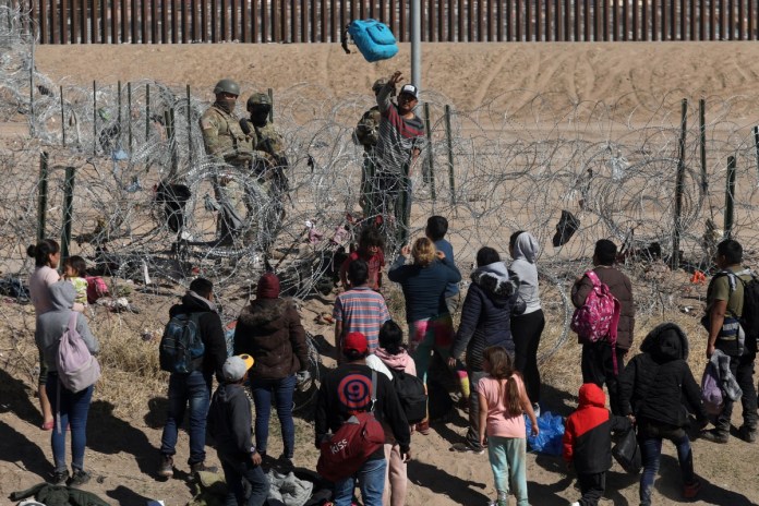 Agentes de la Guardia Nacional de Texas bloquean el paso a través de una cerca de púas a un grupo de migrantes que buscan asilo en Estados Unidos desde Ciudad Juárez, estado de Chihuahua, México, el 30 de enero de 2024.