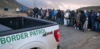 Solicitantes de asilo esperan en fila para ser procesados ​​por la Patrulla Fronteriza en un campamento improvisado cerca de la frontera entre Estados Unidos y México al este de Jacumba, condado de San Diego, California, el 2 de enero de 2024