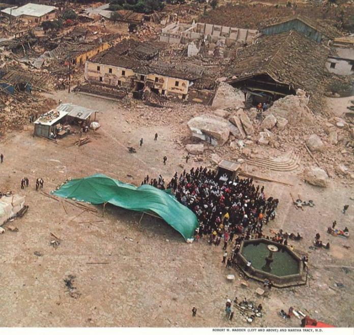 Foto National Geographic volumen 160Un grupo de personas se congregaba en una plaza, alrededor se veía construcciones destruidas.