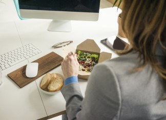 Mujer comiendo ensalada para el almuerzo en su escritorio. Foto: Envato