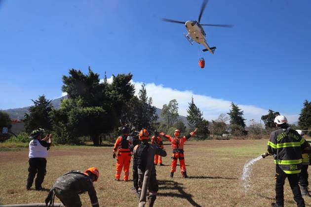 Personal de Conred y socorristas coordinan el envío de helicópteros con agua hacia el Volcán de Agua. Foto /CONRED.