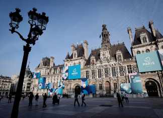 Fotografía tomada en París el 21 de marzo de 2024 muestra una vista del ayuntamiento de París decorado con carteles de los Juegos Olímpicos y Paralímpicos de París 2024. Foto: STEPHANE DE SAKUTIN - AFP/La Hora