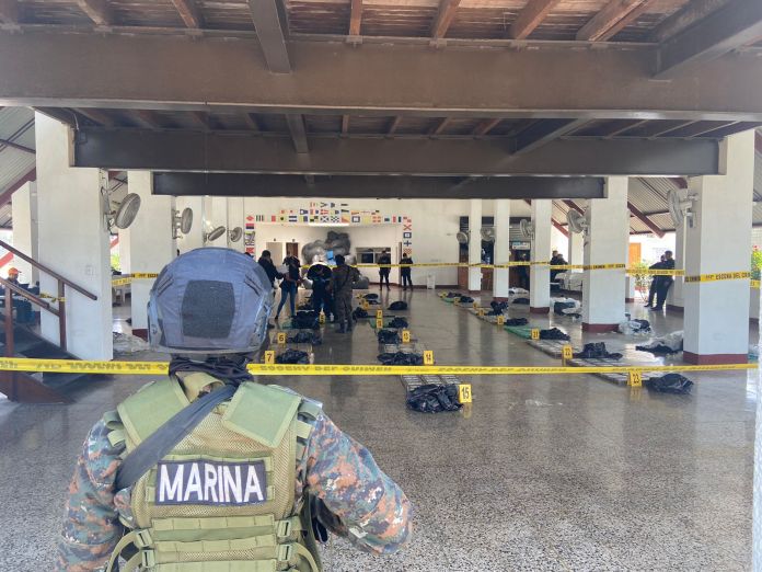 Elementos de la Marina de la Defensa Nacional resguardan a fiscales del Ministerio Público (MP) mientras realizan pruebas de campo a la posible droga incautada en el Pacífico. Foto: Ejército de Guatemala