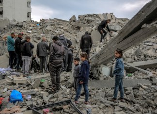 Los palestinos inspeccionan los escombros de un edificio, después de que fuera destruido en un ataque israelí la noche anterior, en el barrio Rimal de la ciudad de Gaza el 16 de marzo de 2024, en medio de batallas en curso entre Israel y el movimiento palestino Hamas. (Foto de AFP)