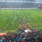 Esta fotografía tomada y publicada el 17 de marzo de 2024 en Trabzon por la agencia de noticias turca DHA (Agencia de Noticias Demiroren) muestra a los seguidores del Trabzonspor entrando al campo durante el partido de fútbol de la Super Lig de Turquía entre Trabzonspor y Fenerbahce en el Papara Park. (Foto de Handout / DHA (Agencia de Noticias Demiroren) / AFP)