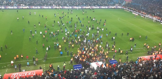 Esta fotografía tomada y publicada el 17 de marzo de 2024 en Trabzon por la agencia de noticias turca DHA (Agencia de Noticias Demiroren) muestra a los seguidores del Trabzonspor entrando al campo durante el partido de fútbol de la Super Lig de Turquía entre Trabzonspor y Fenerbahce en el Papara Park. (Foto de Handout / DHA (Agencia de Noticias Demiroren) / AFP)