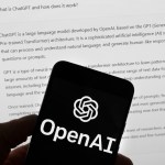 El logotipo de OpenAI puede apreciarse en un teléfono celular frente a la pantalla de una computadora que muestra los resultados de una búsqueda en Chat GPT, el 21 de marzo de 2023, en Boston. (AP Foto/Michael Dwyer, Archivo)