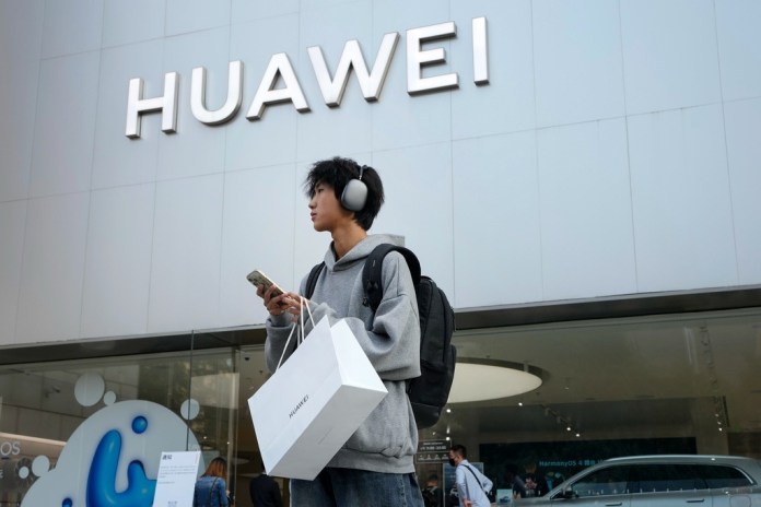 ARCHIVO - Un cliente lleva sus productos adquiridos en una tienda de Huawei tras asistir a una conferencia de lanzamiento de nuevos productos en Beijing, el 25 de septiembre de 2023. (AP Foto/Andy Wong, Archivo)