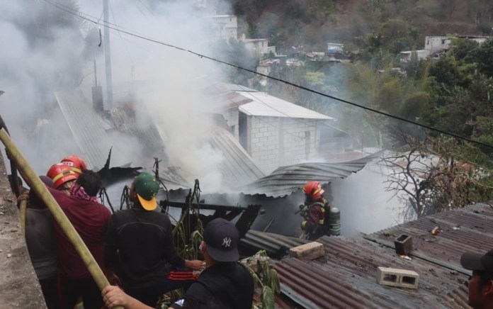 Bomberos y vecinos luchan para sofocar las llamas que amenazan a algunas viviendas en la zona 6. Foto / Bomberos Municipales.