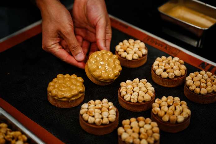 El pastelero de Niza Philippe Tayac muestra tartelettes con avellanas y chocolate "rubio". (Foto de Dimitar DILKOFF / AFP)
