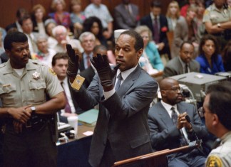 En esta foto del 21 de junio de 1995, O.J. Simpson alza sus manos al ponerse unos guantes ante el jurado en su juicio por doble asesinato en Los Ángeles. Simpson ha fallecido. Tenía 76 años. (Vince Bucci/Pool Foto vía AP, archivo)