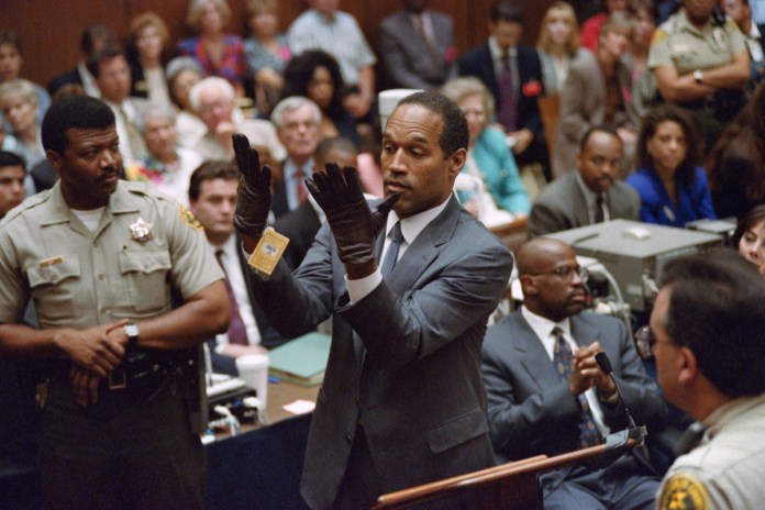 En esta foto del 21 de junio de 1995, O.J. Simpson alza sus manos al ponerse unos guantes ante el jurado en su juicio por doble asesinato en Los Ángeles. Simpson ha fallecido. Tenía 76 años. (Vince Bucci/Pool Foto vía AP, archivo)