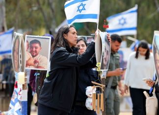 Los israelíes visitan un monumento con retratos de personas tomadas como rehenes o asesinadas en el ataque de Hamas al festival de música Supernova el 7 de octubre en el lugar del festival cerca del Kibbutz Reim en el sur de Israel el 10 de abril de 2024. (Foto de JACK GUEZ / AFP)