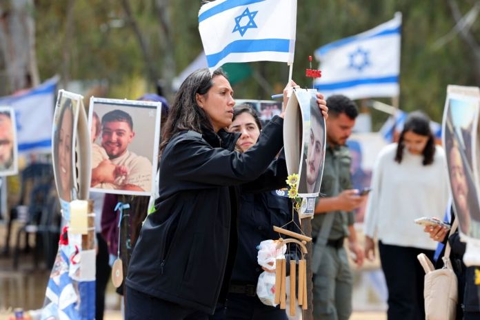 Los israelíes visitan un monumento con retratos de personas tomadas como rehenes o asesinadas en el ataque de Hamas al festival de música Supernova el 7 de octubre en el lugar del festival cerca del Kibbutz Reim en el sur de Israel el 10 de abril de 2024. (Foto de JACK GUEZ / AFP)